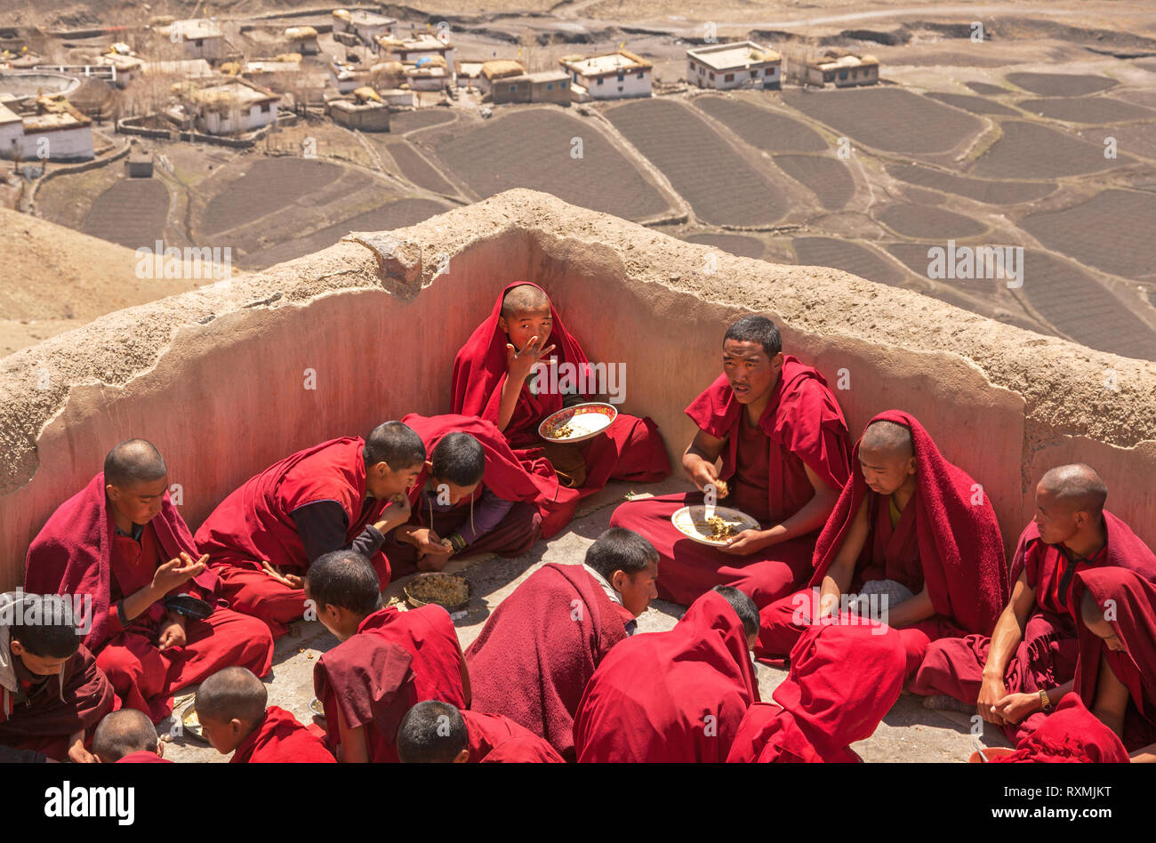 SPITI, INDIEN - 28. APRIL 2016: Gruppe junger Mönche Üben der tibetische Buddhismus haben das Frühstück auf dem Dach der wichtigsten Kloster in Spiti, Indien auf der Apr Stockfoto