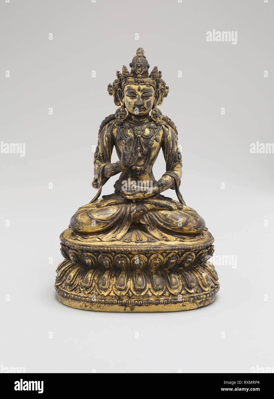 Eine der fünf Himmlischen Buddhas, sitzt mit Händen in Gesten der Meditation (Dhyanamudra) und Sicherheit (Abhaymudra). China. Datum: 1403-1424. Abmessungen: 18 × 12,3 × 9,3 cm (7 1/8 x 4 7/8 x 3 5/8 in.). Vergoldete Kupferlegierung. Herkunft: China. Museum: Das Chicago Art Institute. Stockfoto