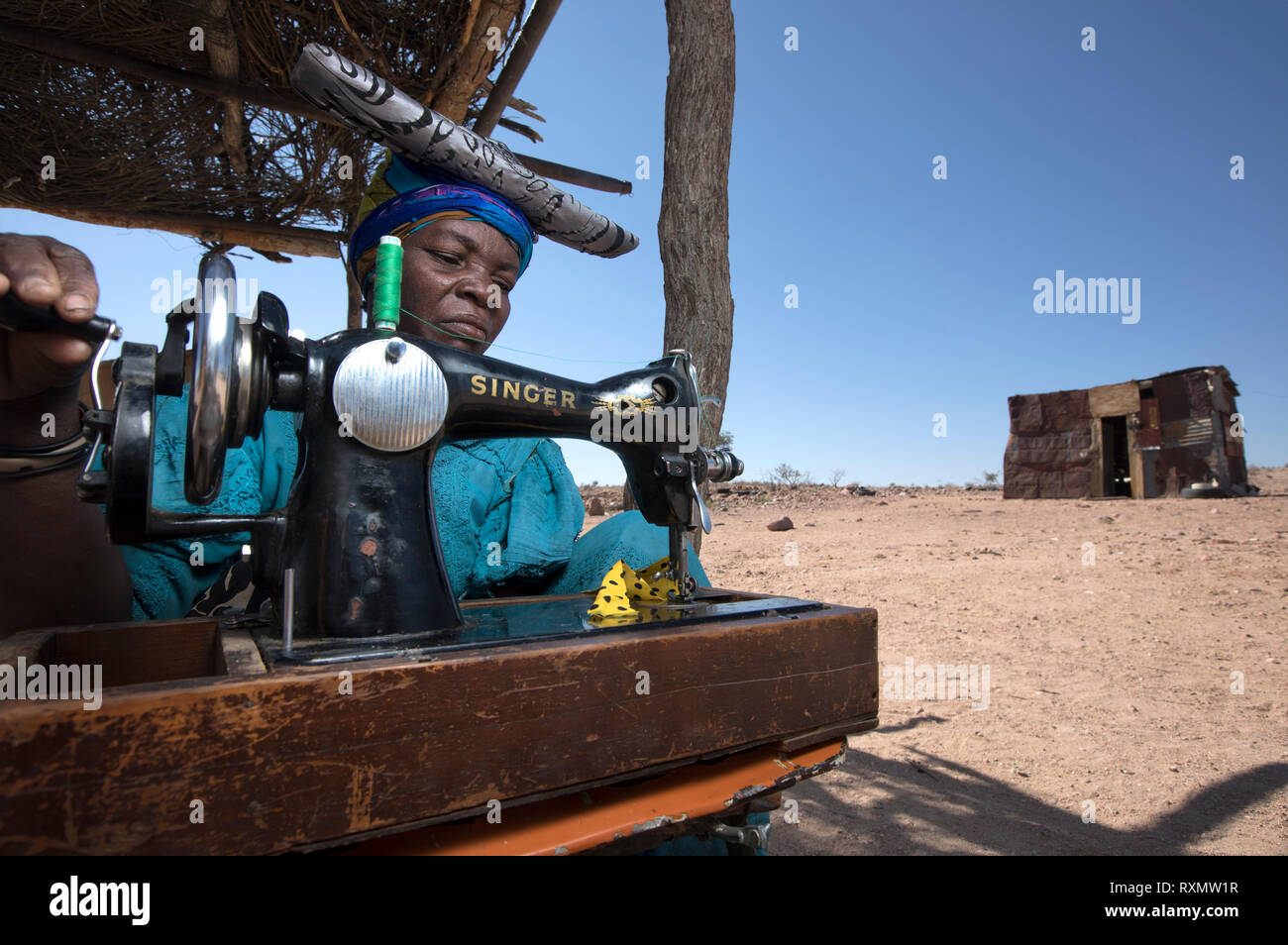 Die Herero Frau näht Miniatur Kleider für Puppen verkauft sie an Touristen. Stockfoto