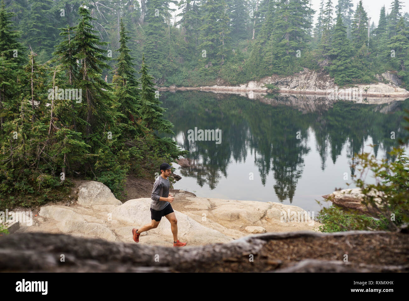 Ein männlicher Trail Runner durch Cypress Provincial Park, British Columbia, Kanada läuft Stockfoto