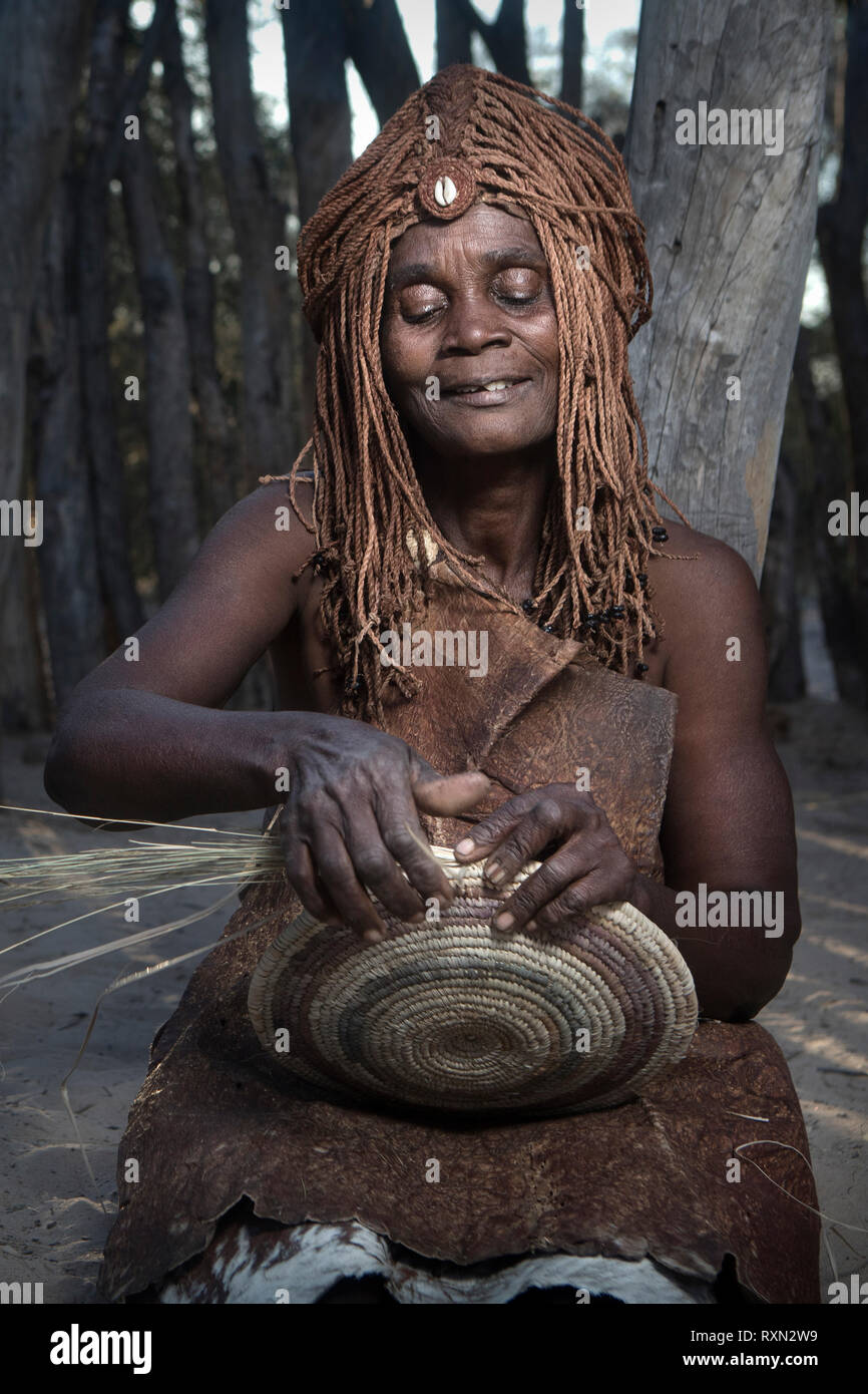 Eine Mbunza Frau weben einen Korb. Stockfoto