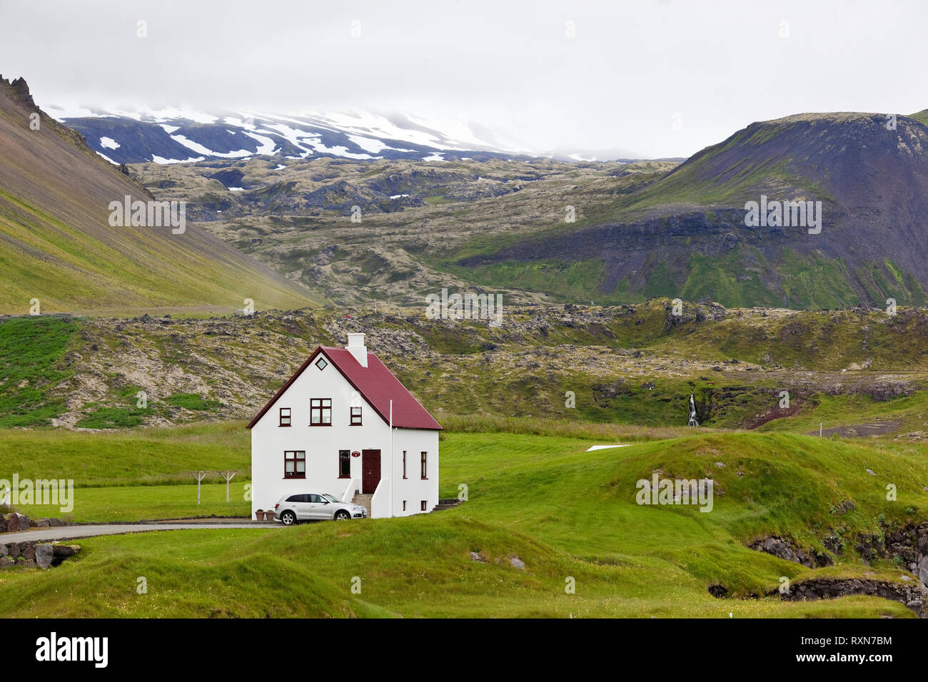 Haus am Fuß des Mt. Stapafell (links) und Snæfellsjökull Gletscher (zurück) in Arnastapi, Halbinsel Snaefellsnes, Island Stockfoto