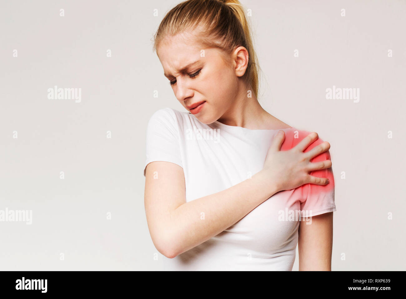 Junge Frau mit Schmerzen in der Schulter Stockfoto