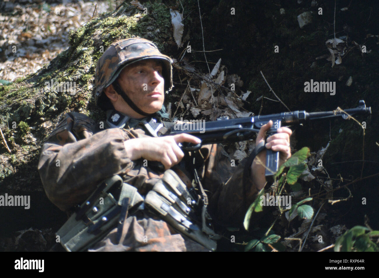 Ein WW2 Deutscher Reenactor trägt die Uniform der Waffen-SS ein deutscher Soldat einen MP40 Maschine Pistole Stockfoto