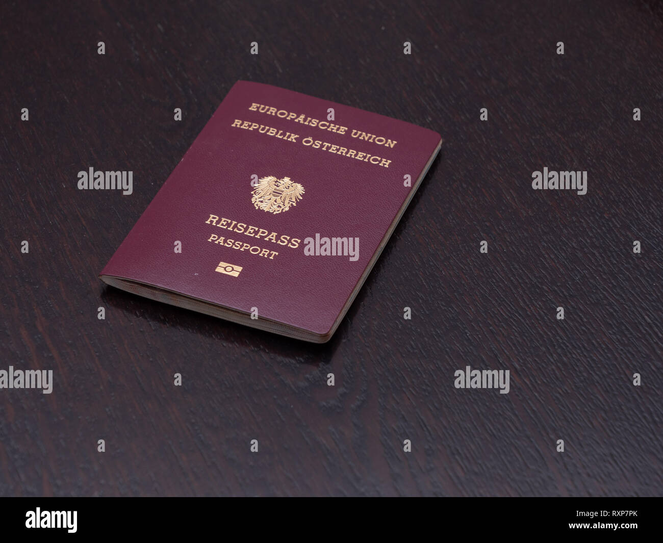 Rot Europäischen Pass österreichischer Staatsangehörigkeit auf einen hölzernen Tisch Stockfoto