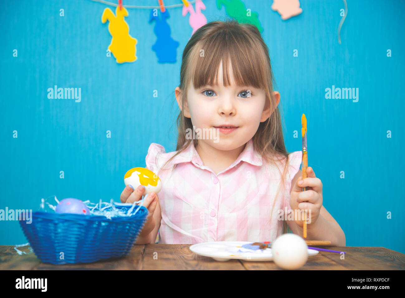 Nett lächelnden Mädchen malen bunte Ostereier Stockfoto