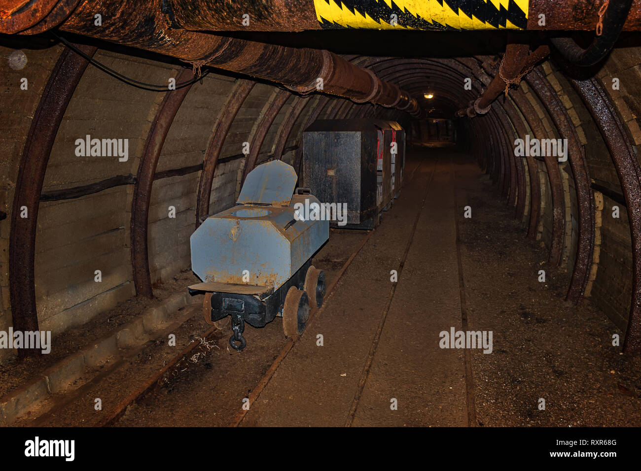 Alte wc Wagen und Metall Grubenbahn in meinem Tunnel mit hölzernen Holzausbau Stockfoto