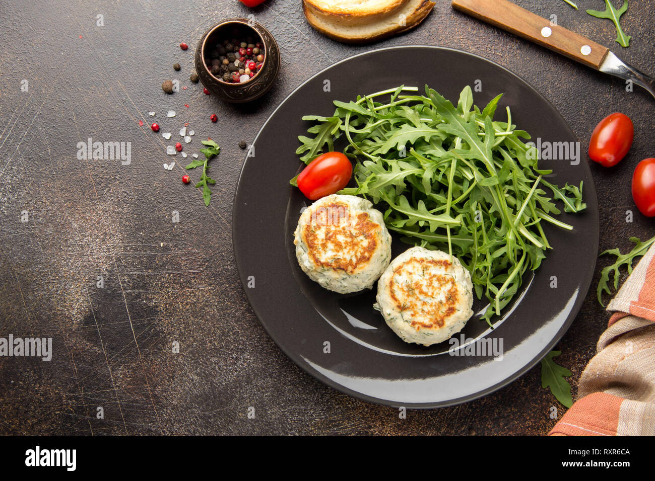 Fried Chicken Schnitzel mit Kräutern, leckeren, gesunden Mittagessen, Essen für Kinder, Diät. Frikadellen mit Salat auf dunklem Hintergrund Stockfoto