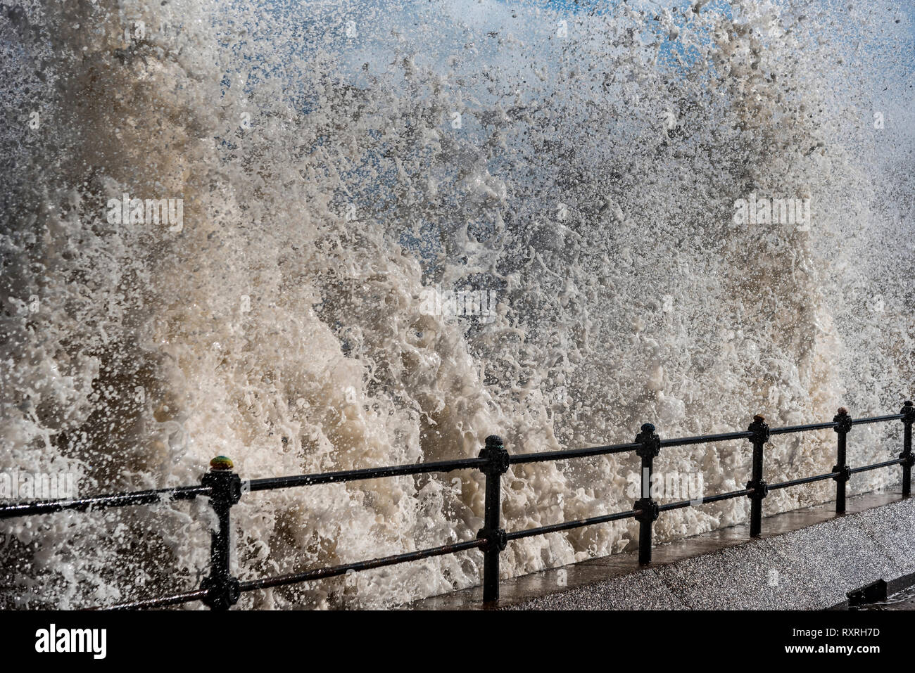 New Brighton, Merseyside, UK. 10. Mär 2019. Wellen Teig der Egremont Promenade am Fluss Mersey mit Liverpool skyline im Hintergrund während der starken Winden. Quelle: John Davidson/Alamy leben Nachrichten Stockfoto