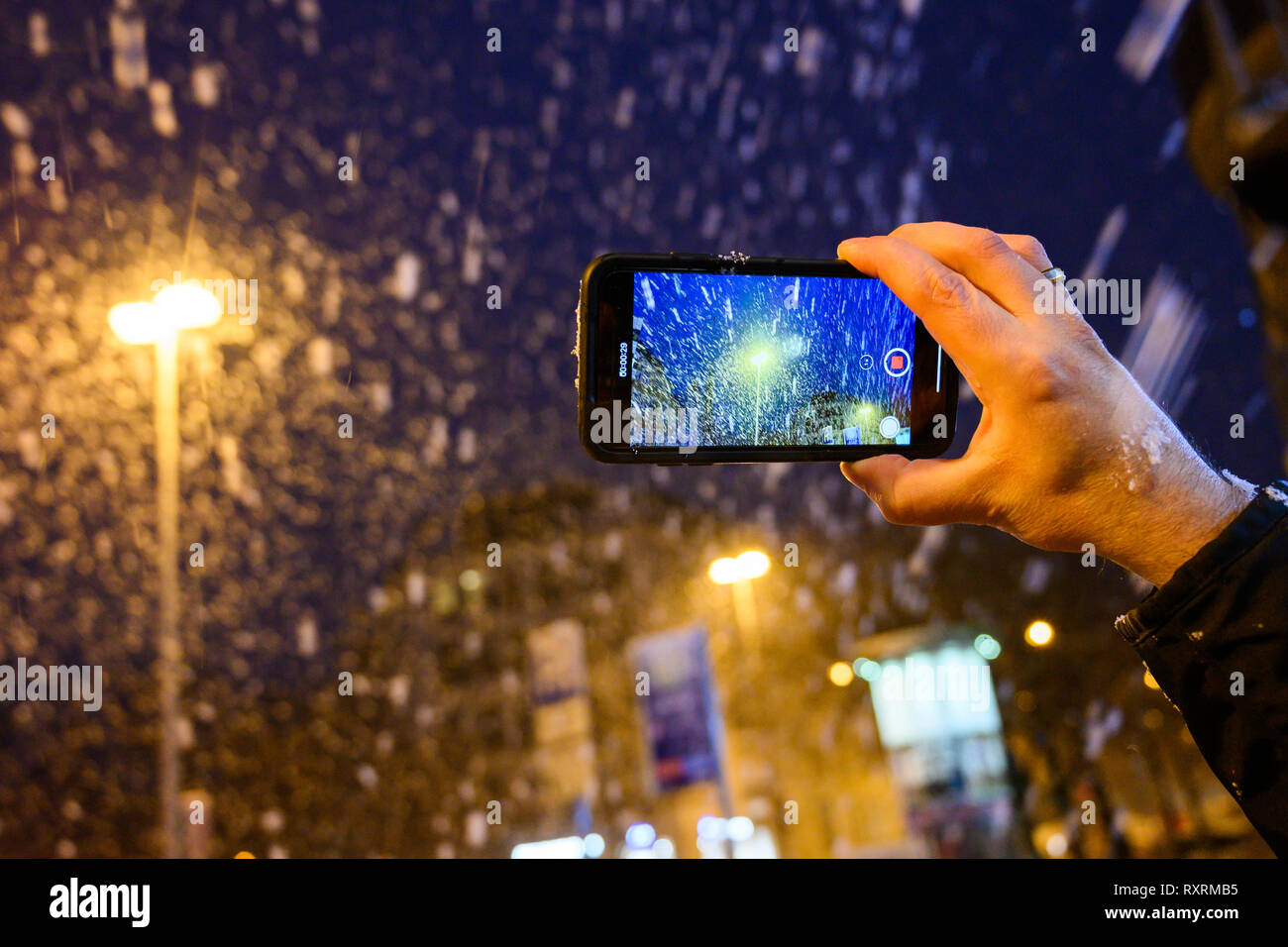 Hannover, Deutschland. 10 Mär, 2019. Ein Mann Filme das Schneegestöber mit seinem Smartphone. Credit: Christophe Kirschtorte/dpa/Alamy leben Nachrichten Stockfoto