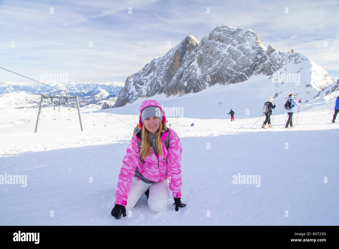 Frau sitzt auf Skiern lope und lächelnd Stockfoto