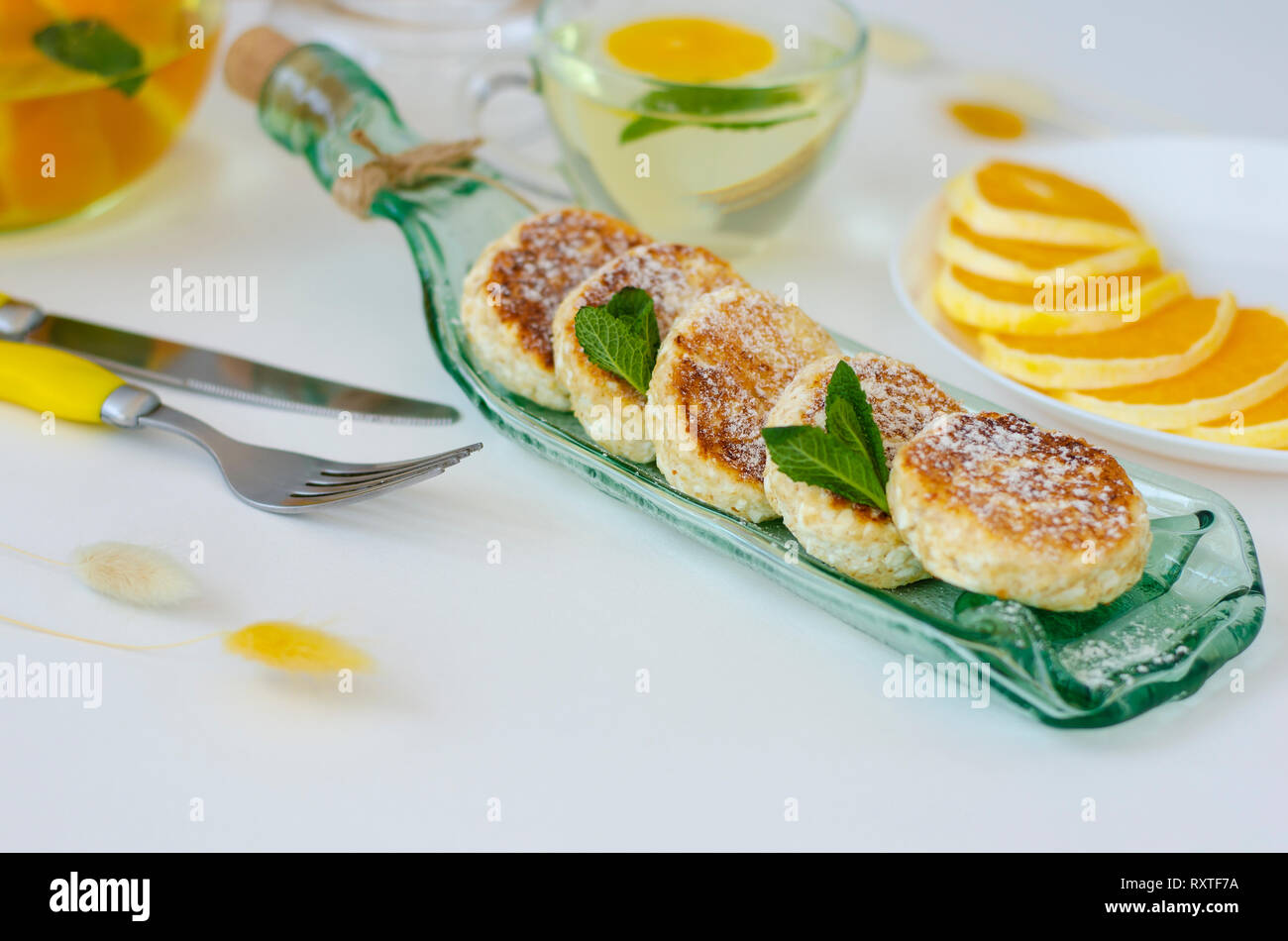 Fritters Von Huttenkase Mit Brombeeren Minze Und Saure Sahne Fur Gesundes Fruhstuck Auf Einer Transparenten Servierteller Teekanne Mit Detox Tee Ernahrung Des Stockfotografie Alamy