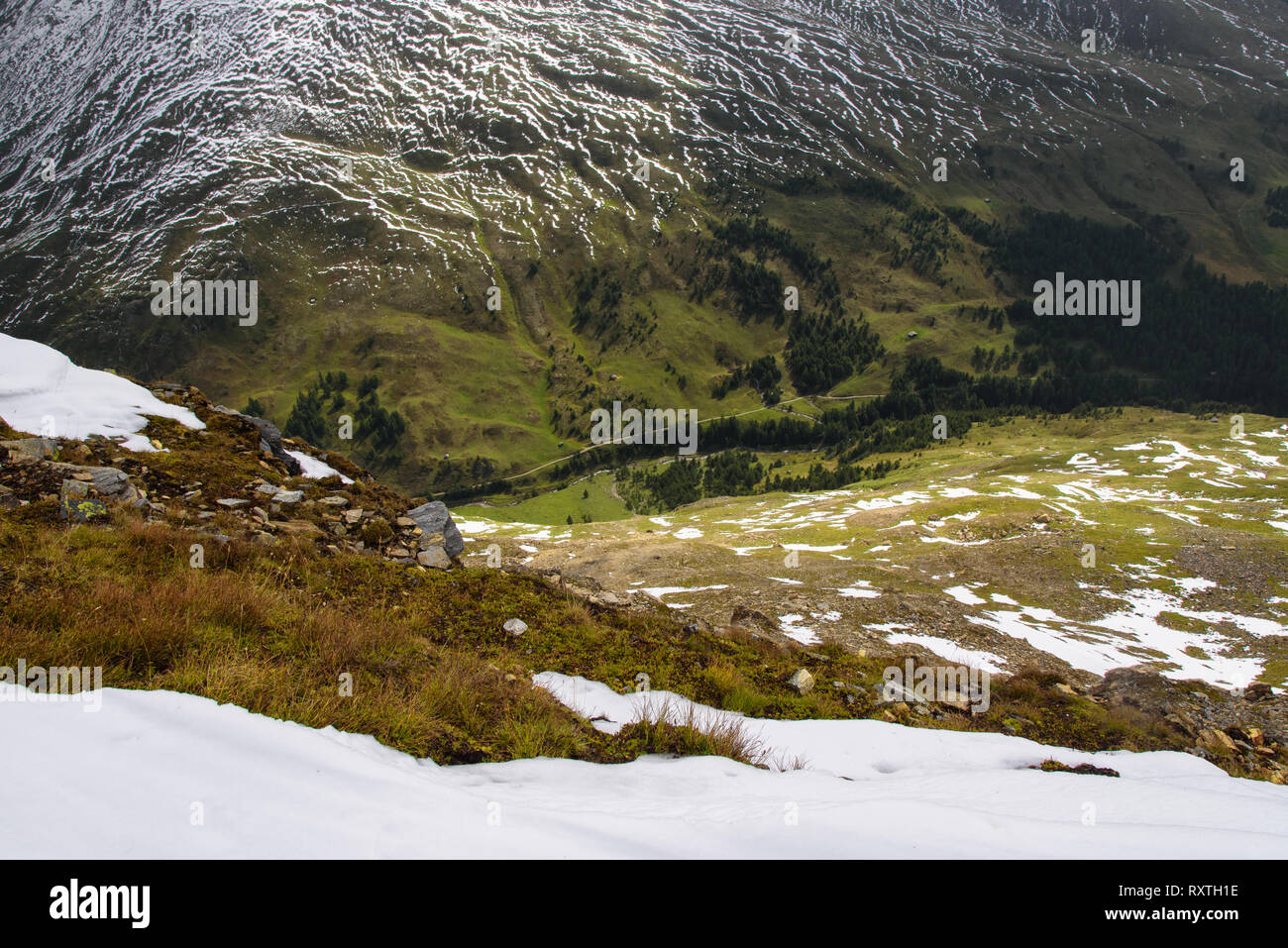 Eine Ansicht aus einem schneebedeckten Gipfel auf einem grünen Tal und Berg hängen teilweise mit Schnee bedeckt, eine abstrakte Natur Hintergrund, Nationalpark Hohe Tauern, Österreich Stockfoto