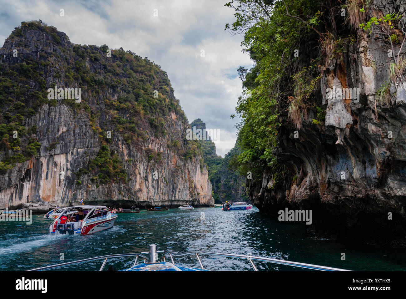 Touristische Ausflugsboote bewegen sich durch die Passage zwischen den Phi Phi Inseln, Thailand Stockfoto