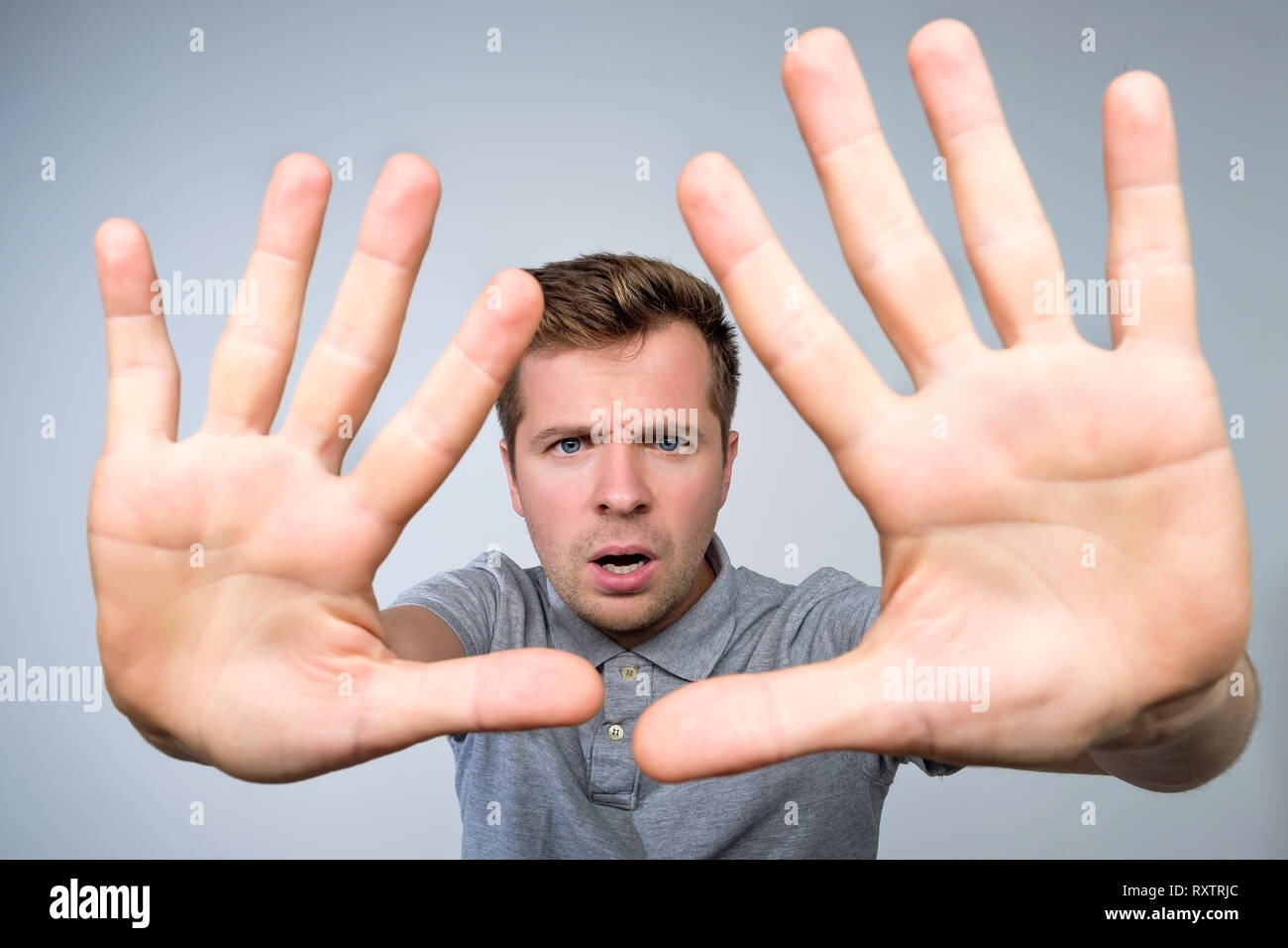 Junge europäische Mann im grauen T-Shirt, das mit hand Stop timeout Geste. Stockfoto