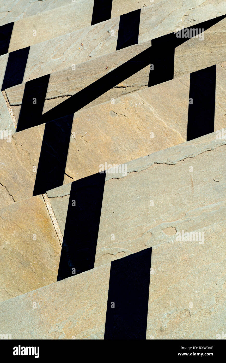 Schatten von Geländer, die von Sun auf der Steinplatte Schritte cast Stockfoto