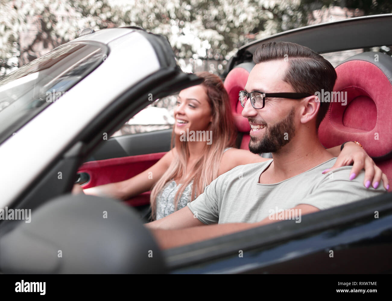 Liebespaar auf dem Vordersitz eines Cabrio Auto sitzen Stockfoto