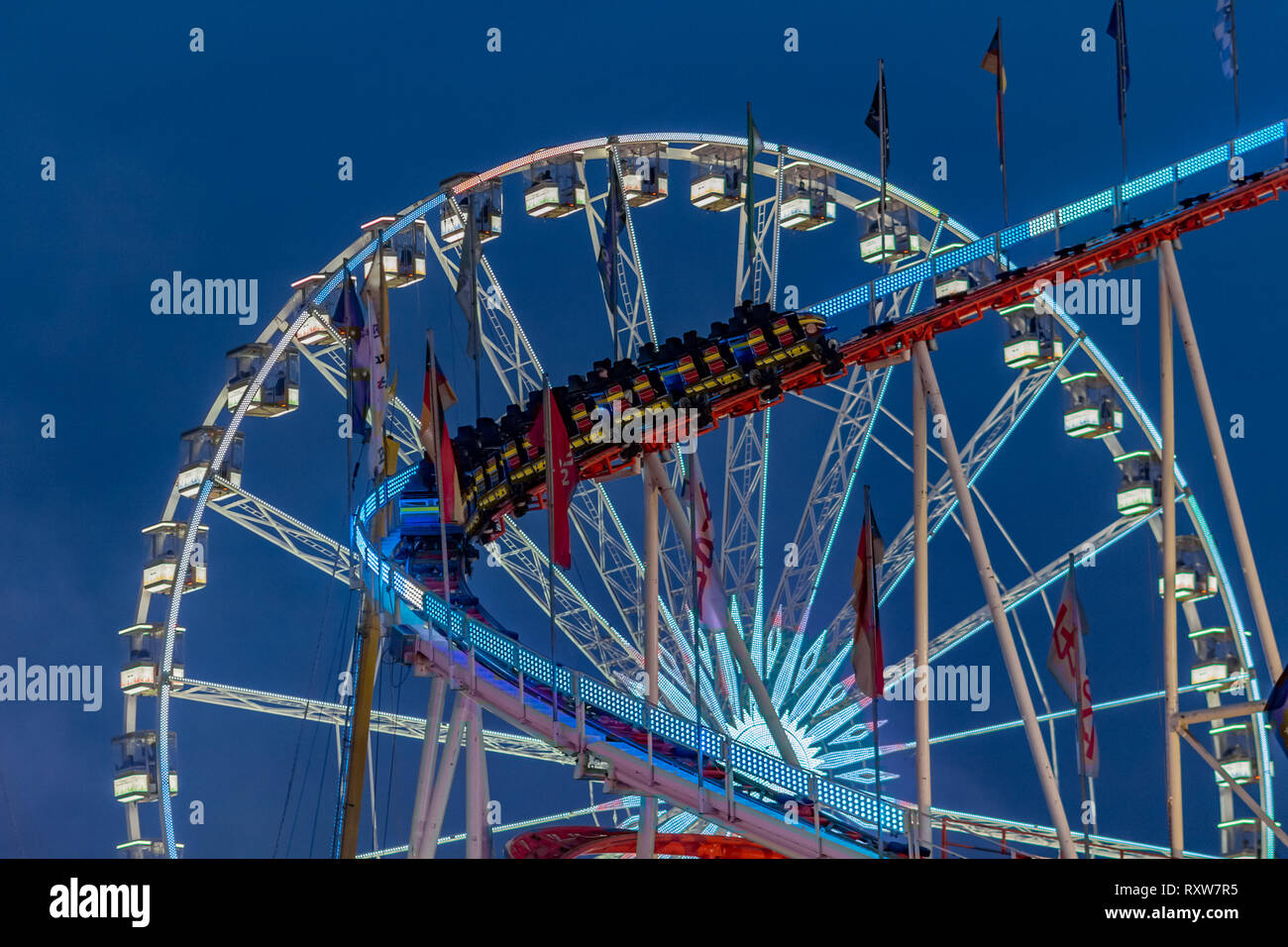 Amusement Park bei Nacht - Riesenrad und Achterbahn in Bewegung Stockfoto