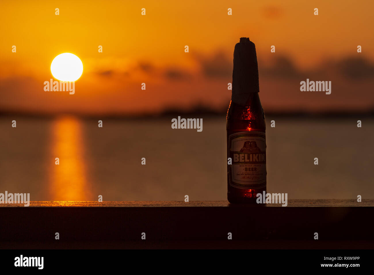 Ein eiskaltes Belikin und eine schöne Ambergris Caye Sonnenuntergang; zwei großartige Dinge über Belize. Belikin ist die größte Brauerei in Belize. Stockfoto