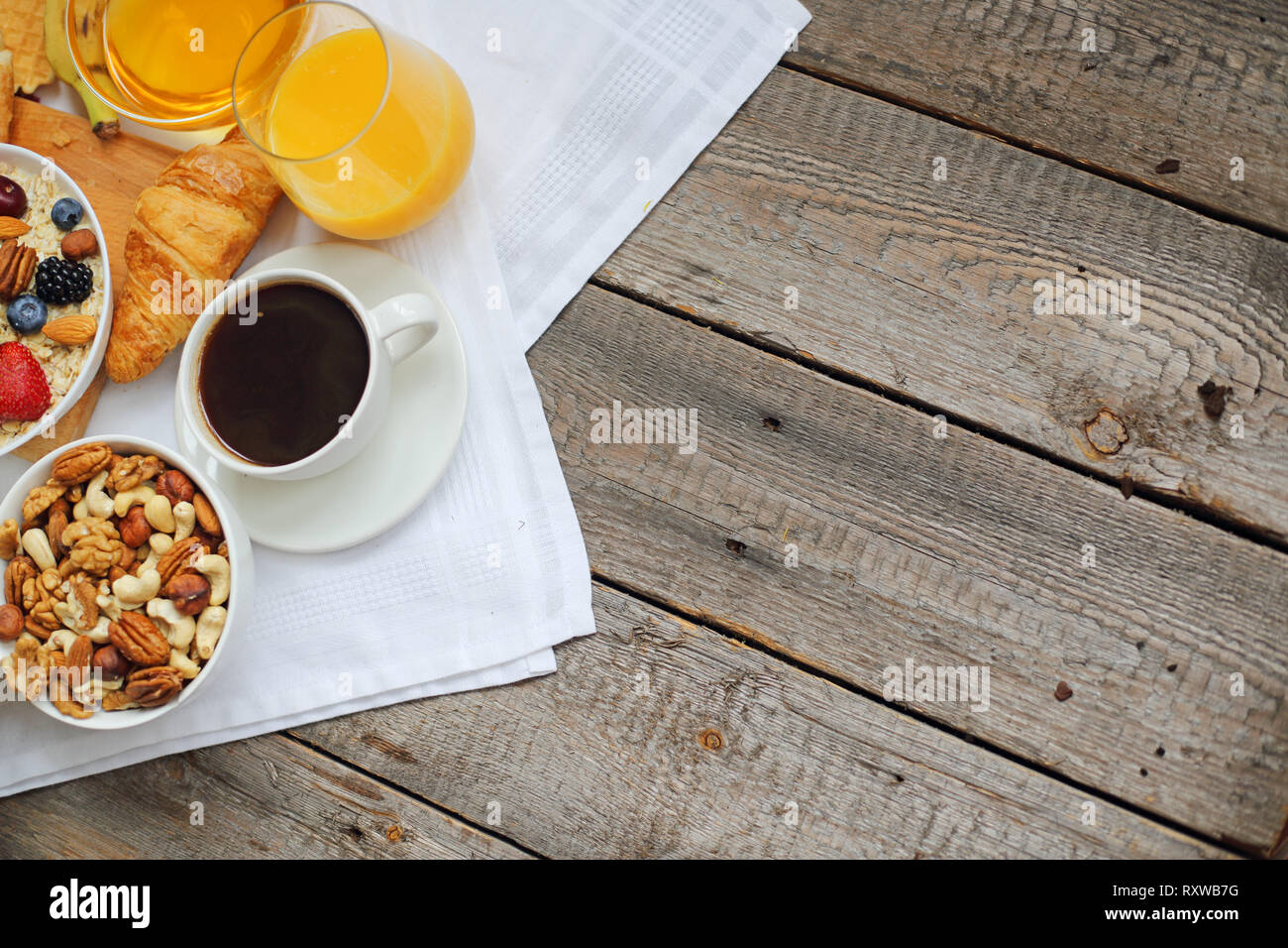 Gesundes Frühstück mit Müsli, Früchte, Beeren, Nüsse, Kaffee, Eier, Honig, Hafer und anderen Nahaufnahme Stockfoto