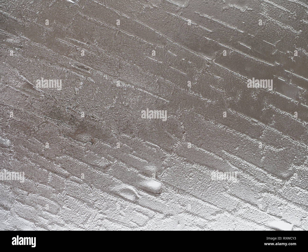 Kanten und die Kristalle an einem frostigen Fenster in einem silber grau dargestellt, und ein abstraktes Muster. Stockfoto