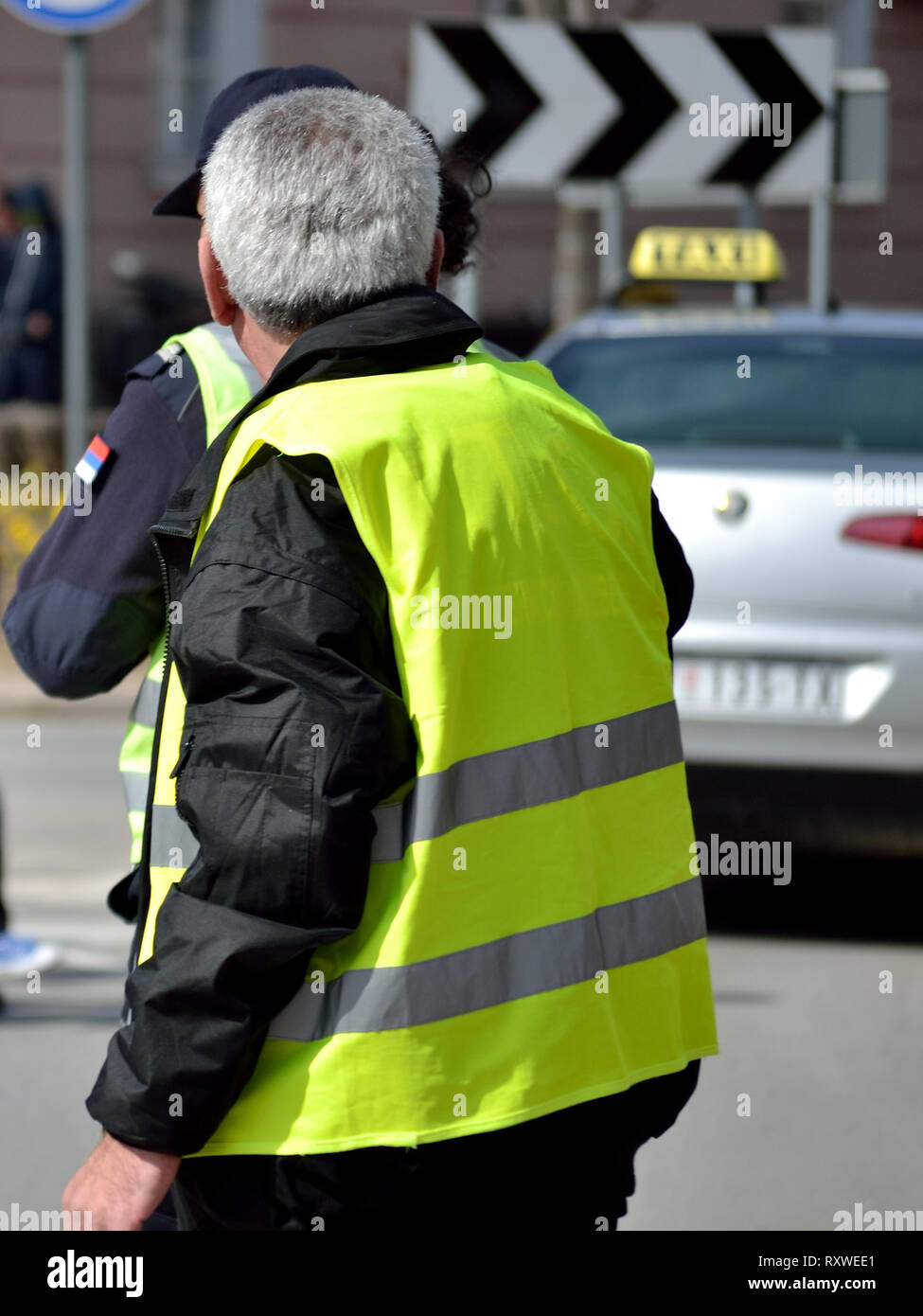 Polizisten patrouillieren, um eine große Veranstaltung in fluoreszierendem Gelb Weste Stockfoto