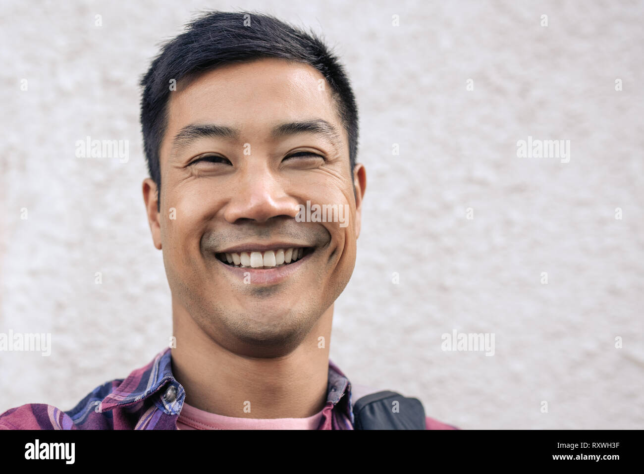 Glückliche junge asiatischer Mann einen selfie in der Stadt Stockfoto