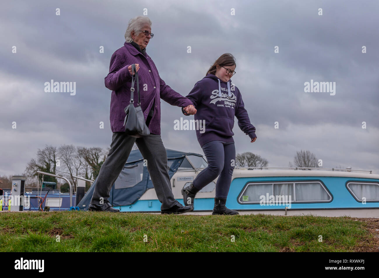 Junges Mädchen mit Down-syndrom mit ihrer Großmutter zu Fuß an den Weißen Mühlen Marina, Earls Barton, Northamptonshire, Großbritannien. Stockfoto