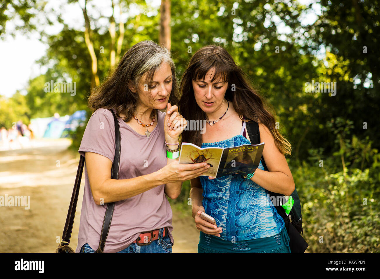 Zwei Damen auf einem Festival guide In das Wilde Festival, Kent, Großbritannien suchen Stockfoto