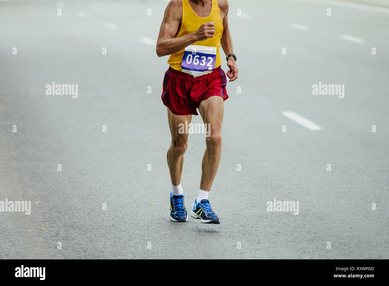 Ältere männliche Athlet runner läuft auf grauem Asphalt Stockfoto