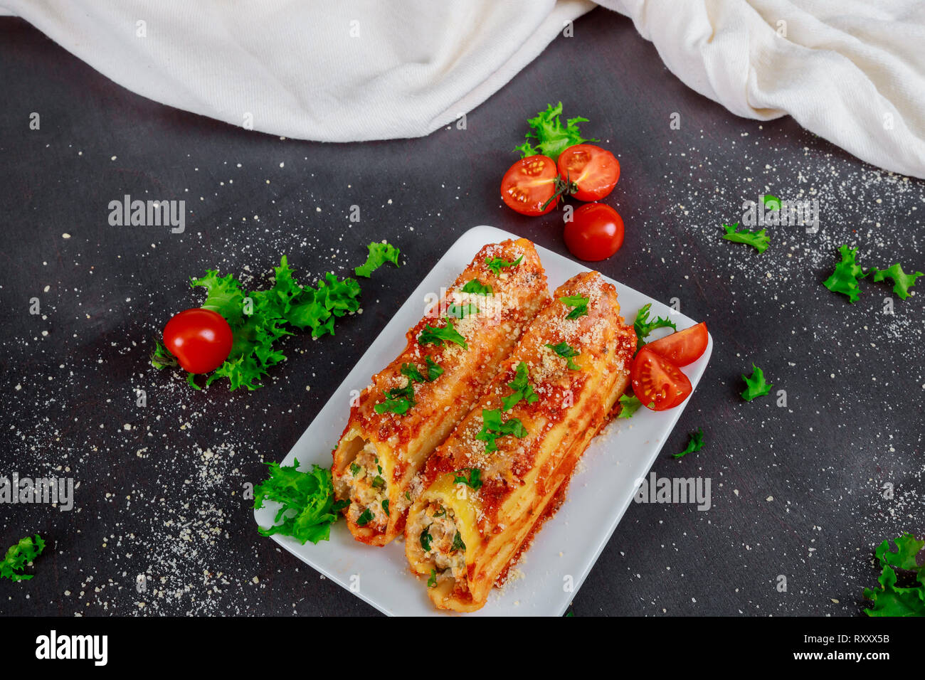 Traditionelle italienische rondelli Cannelloni Pasta mit Tomatensauce auf rustikalen Hintergrund Stockfoto