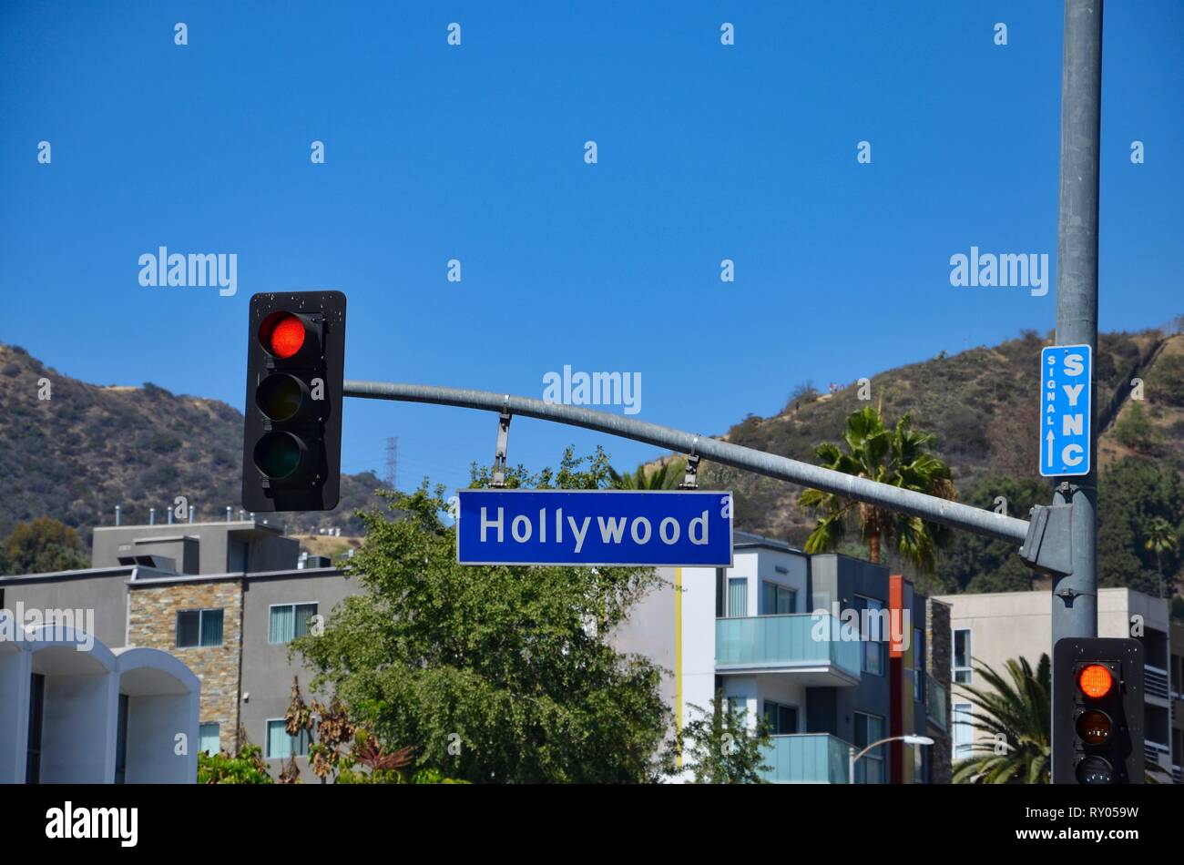Blau Strassenschild Uber Den Bezirk Hollywood In Los Angeles Usa Rote Ampel Gebaude Und Berge Im Hintergrund Baume Und Palmen Stockfotografie Alamy