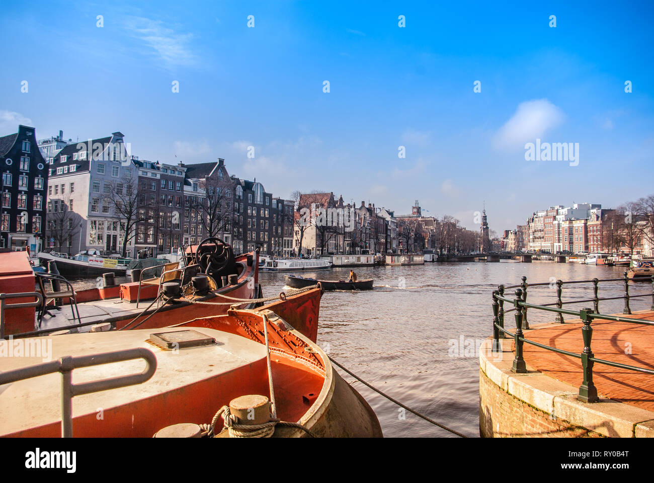 Blick auf den Fluss Amstel und Munt Turm mit Schiffen Bögen im Vordergrund. Farbe verbessert. Stockfoto