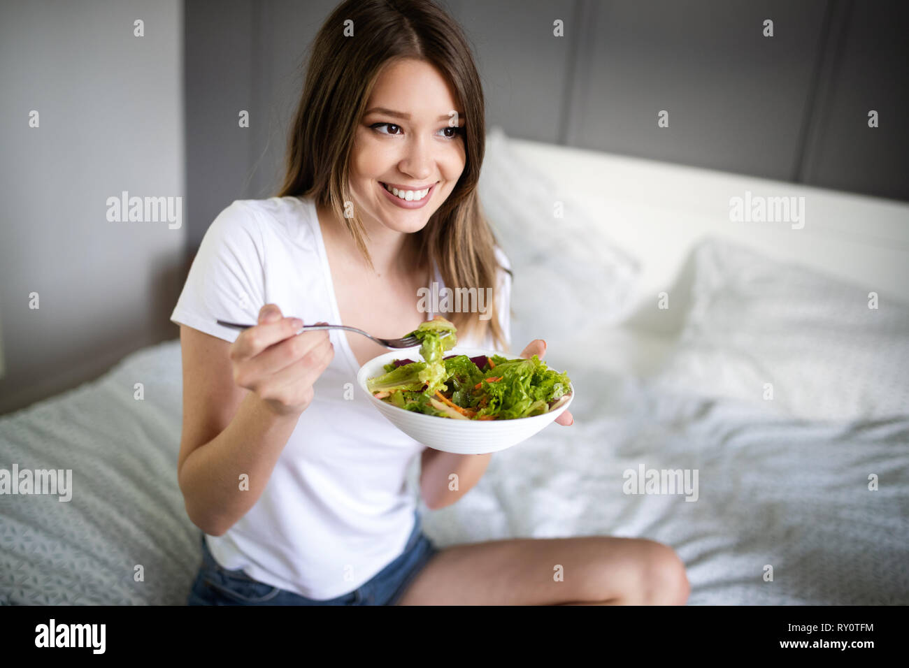 Porträt einer schönen hübsches Mädchen Essen frischer Salat aus einer Schüssel Stockfoto