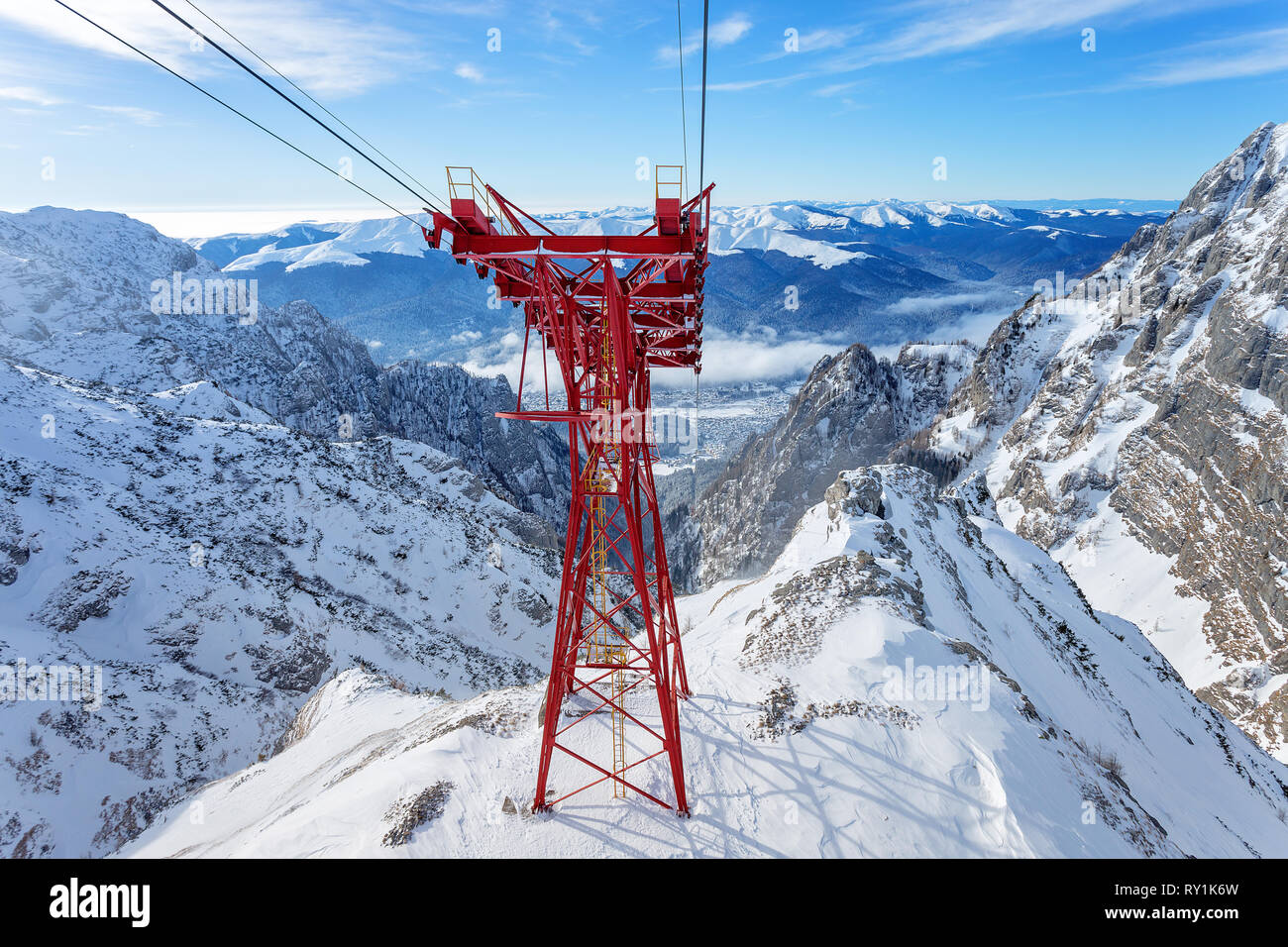 Rotes Kabel Auto Pylon und Kabel weg am Berge Landschaft. Blauer Himmel und massiven Berge im Hintergrund, während Sie im Winter im Skigebiet Stockfoto