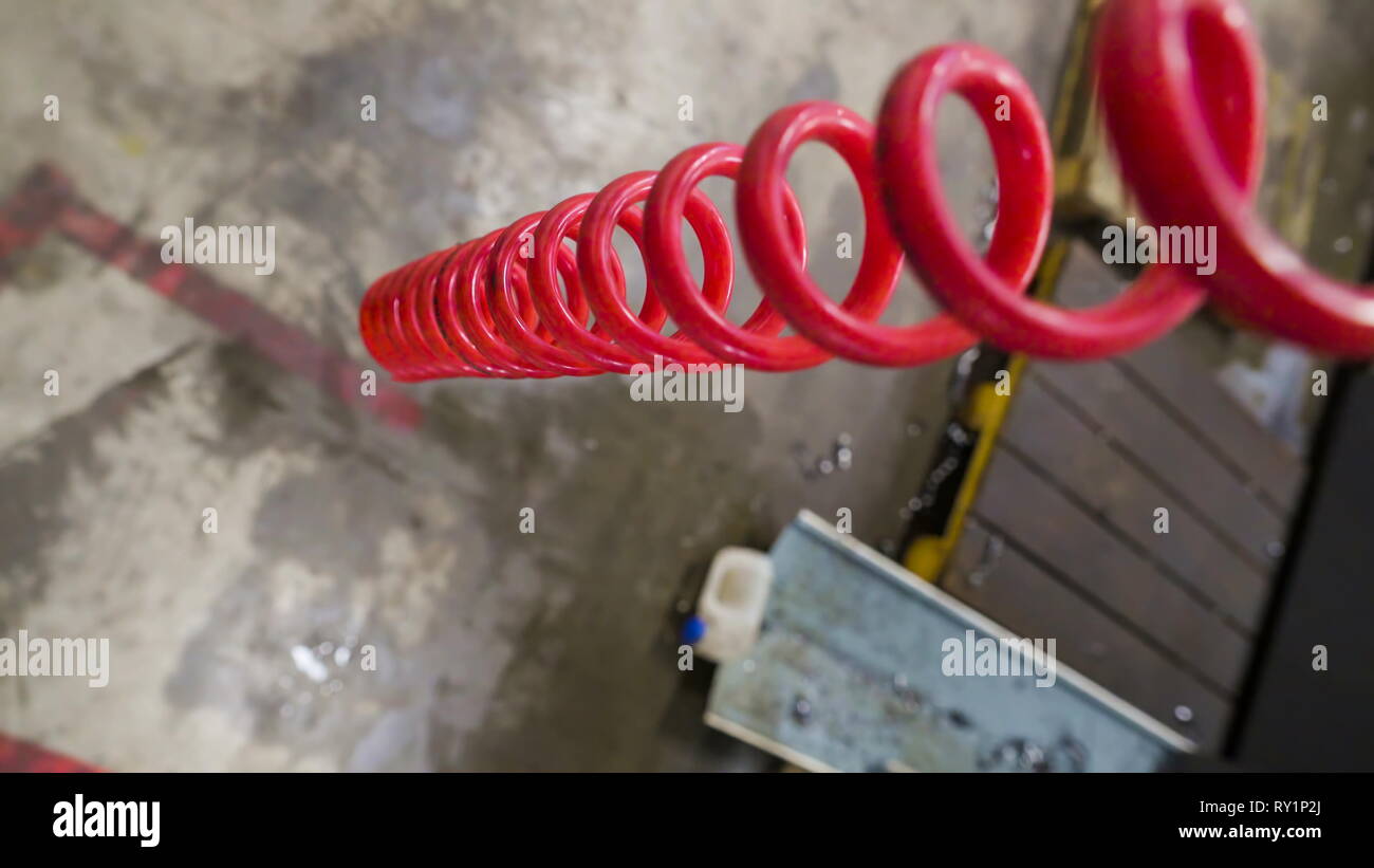 Die rote Feder hängend auf dem Zimmer eines industriellen Fabrik für Stähle Stockfoto