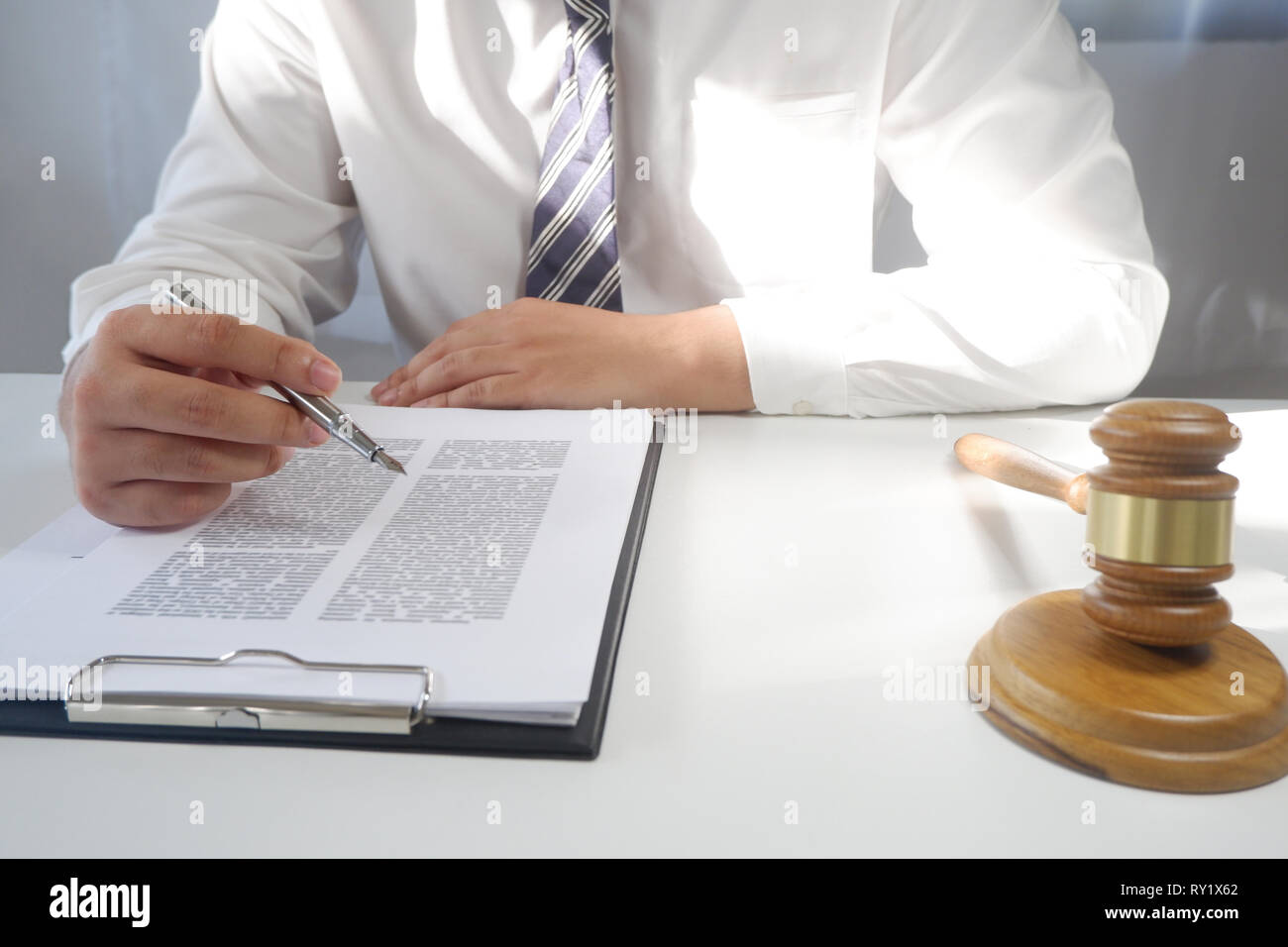 Rechtsberater stellt einen Vertrag mit Hammer und rechtlichen Gesetz. Justiz und Rechtsanwalt Konzept Stockfoto