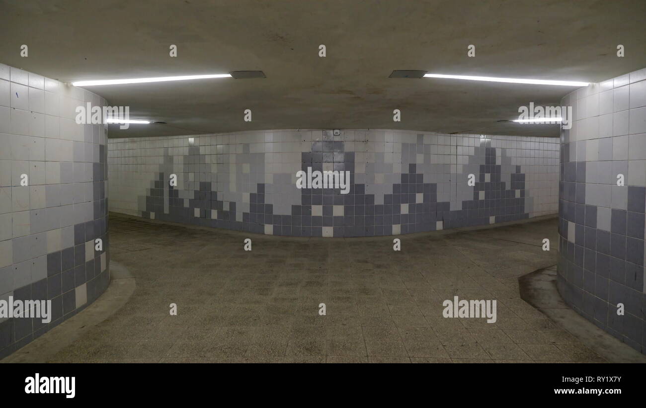 Eine zwei-Wege-Tunnel", der U-Bahn mit grauen Mauern der Steine haben Entwürfe für die Wand und einige flourescent leuchtet auf dem Flur zu erleichtern Stockfoto