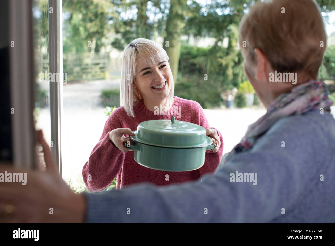 Essen zu bringen, denn ältere Nachbarin Frau Stockfoto