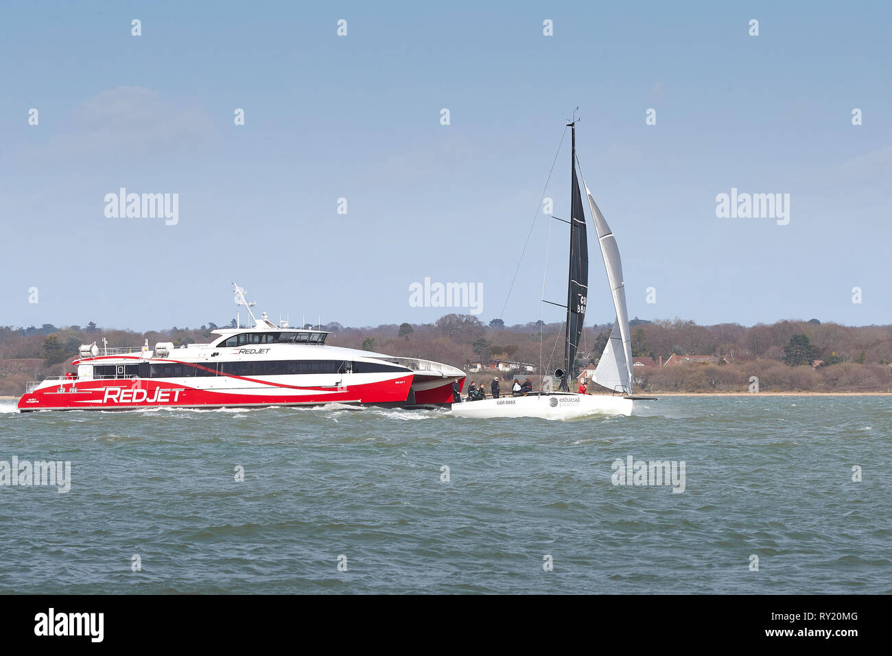 Der Fahrgast Katamaran (SeaCat), Rot Jet 7, Unterwegs von Southampton auf der Insel Wight, führt nahe an einem Segelboot. Southampton, Großbritannien. Stockfoto