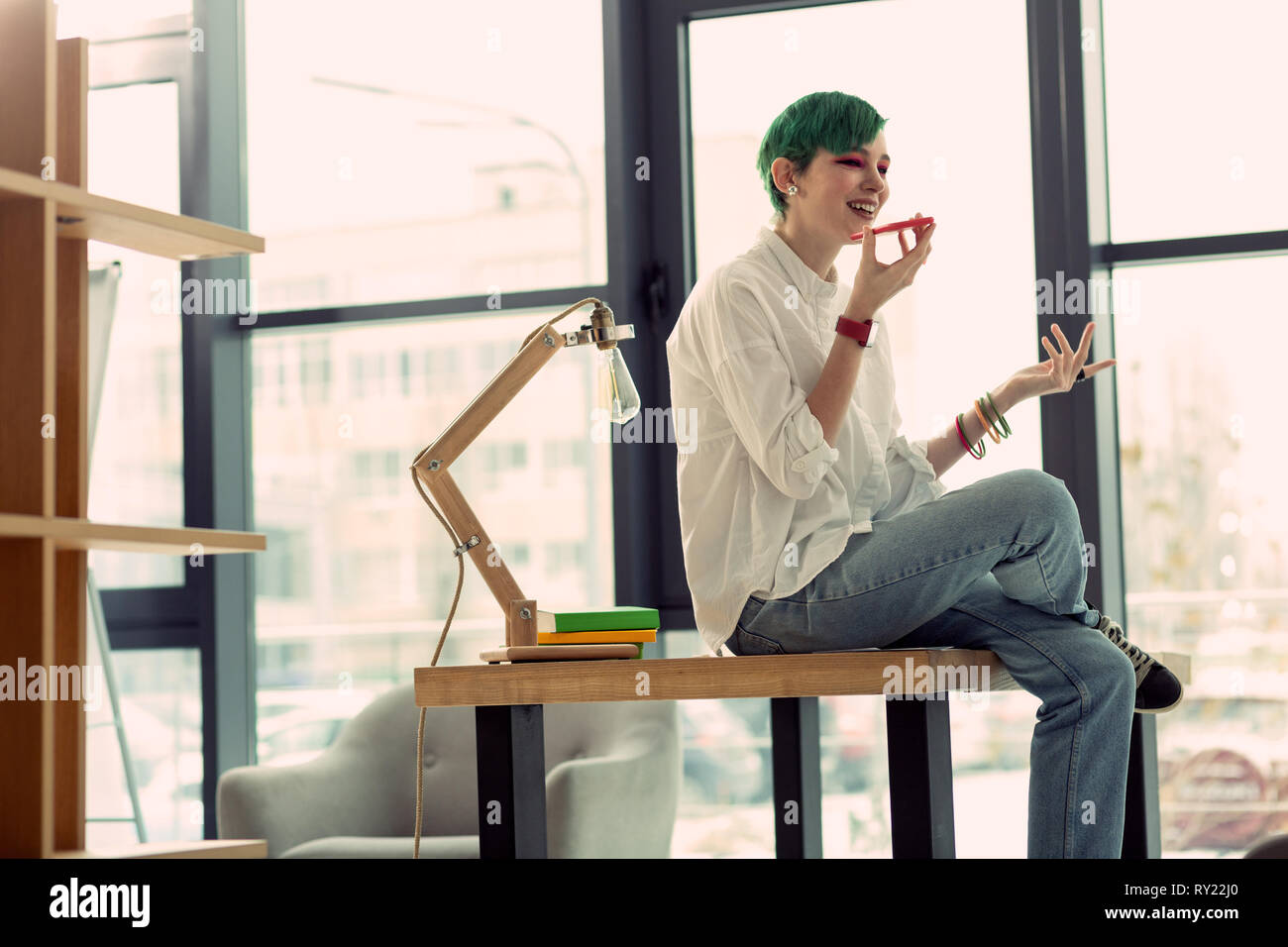 Positive grünhaarige Frau am Telefon Stockfoto