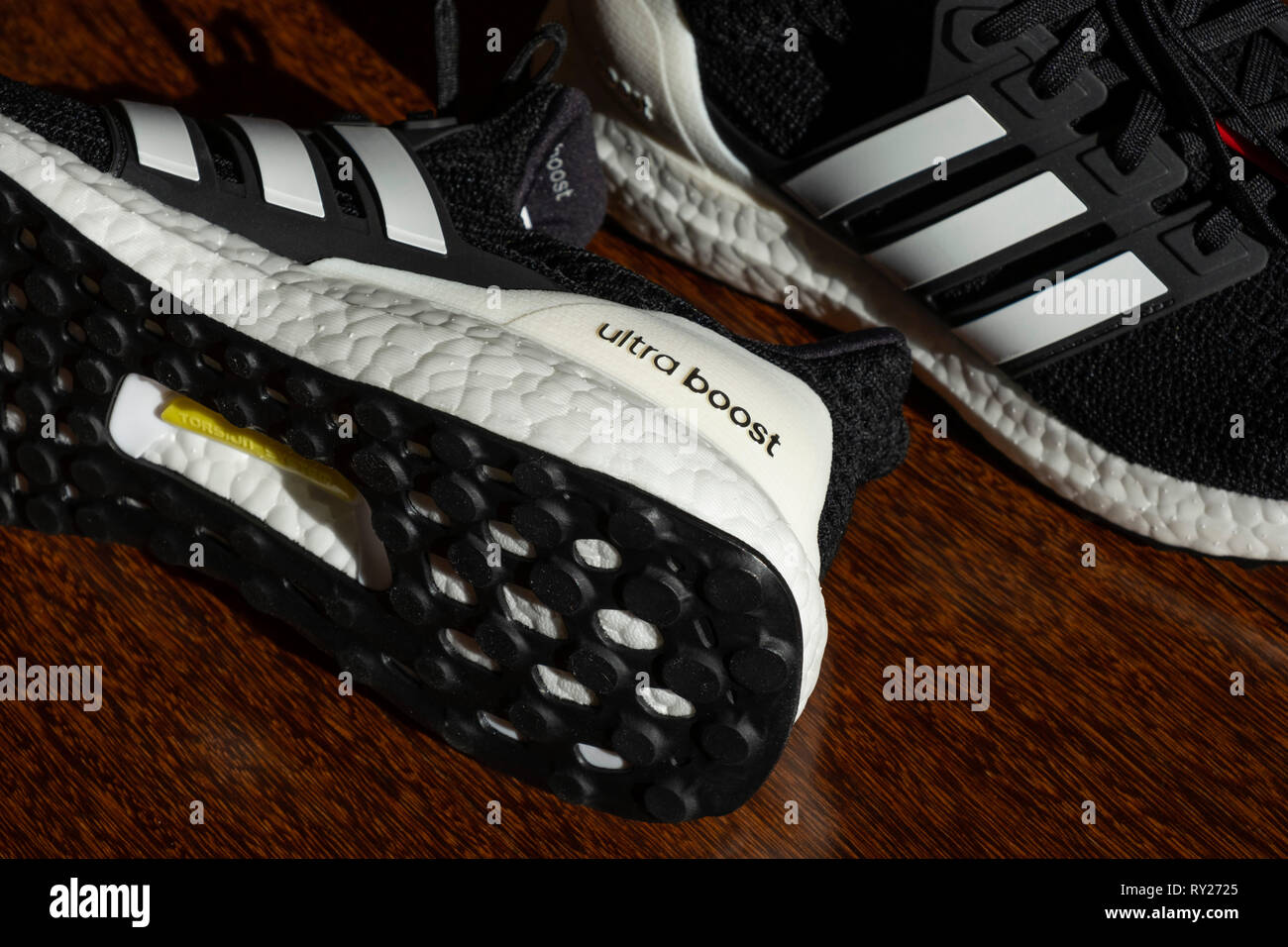 Schwarz Adidas Laufschuhe Ultraboost auf Parkett Stockfoto