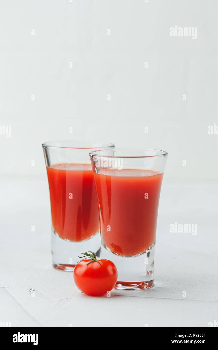 Tomate Bloody Mary würzige Alkohol auf weißem Hintergrund mit kopieren. Cold Bloody Mary cocktail shot in Gläsern und Tomaten. Stockfoto