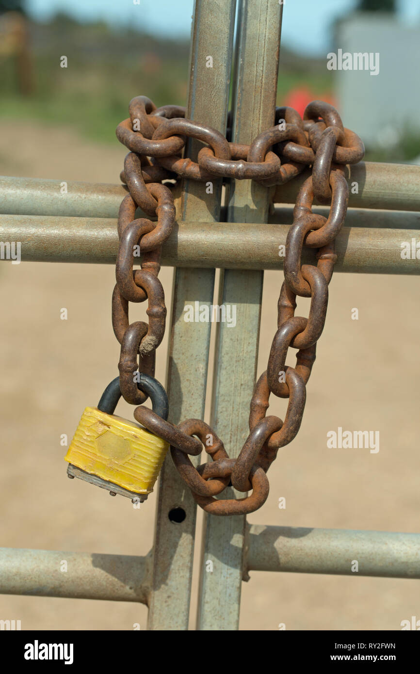 Metal Gates, geschlossen und durch Metall Kette und einem Vorhängeschloss gesichert. Stockfoto