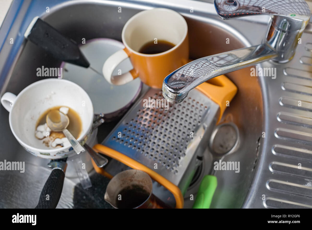 Ein Haufen schmutziger und ungewaschenen Geschirr in der Spüle. Übrig gebliebene Kaffee in Gläser. Stockfoto