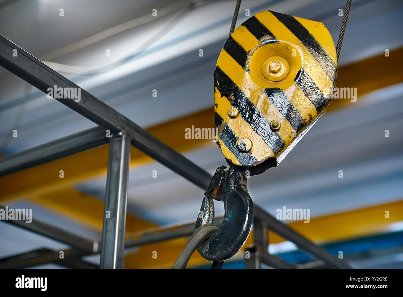 Gelbe Kran aufhängen in der Werkstatt. Anheben der Metallkonstruktion im Zimmer kranausleger. Stockfoto