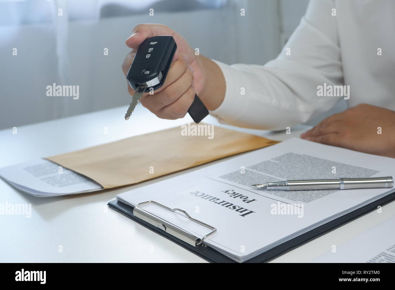 Close-up Hand geben ein autoschlüssel nach der Unterzeichnung eines Dokuments von Auto zu mieten, Auto Versicherung. Stockfoto