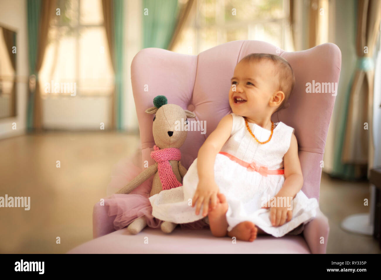 Cute adorable Baby Mädchen spielen mit erste Puppe Stockfoto