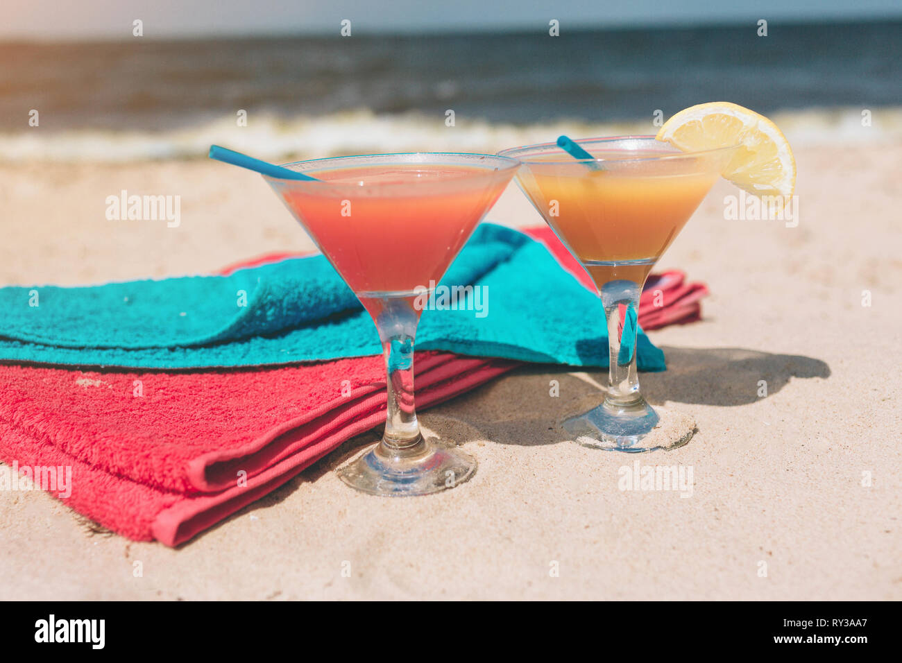 Sommer Konzept: frischen exotischen Cocktail auf Sand Strand. Bunte Handtücher neben liegen. Es ist an der Küste. Paradies. Stockfoto