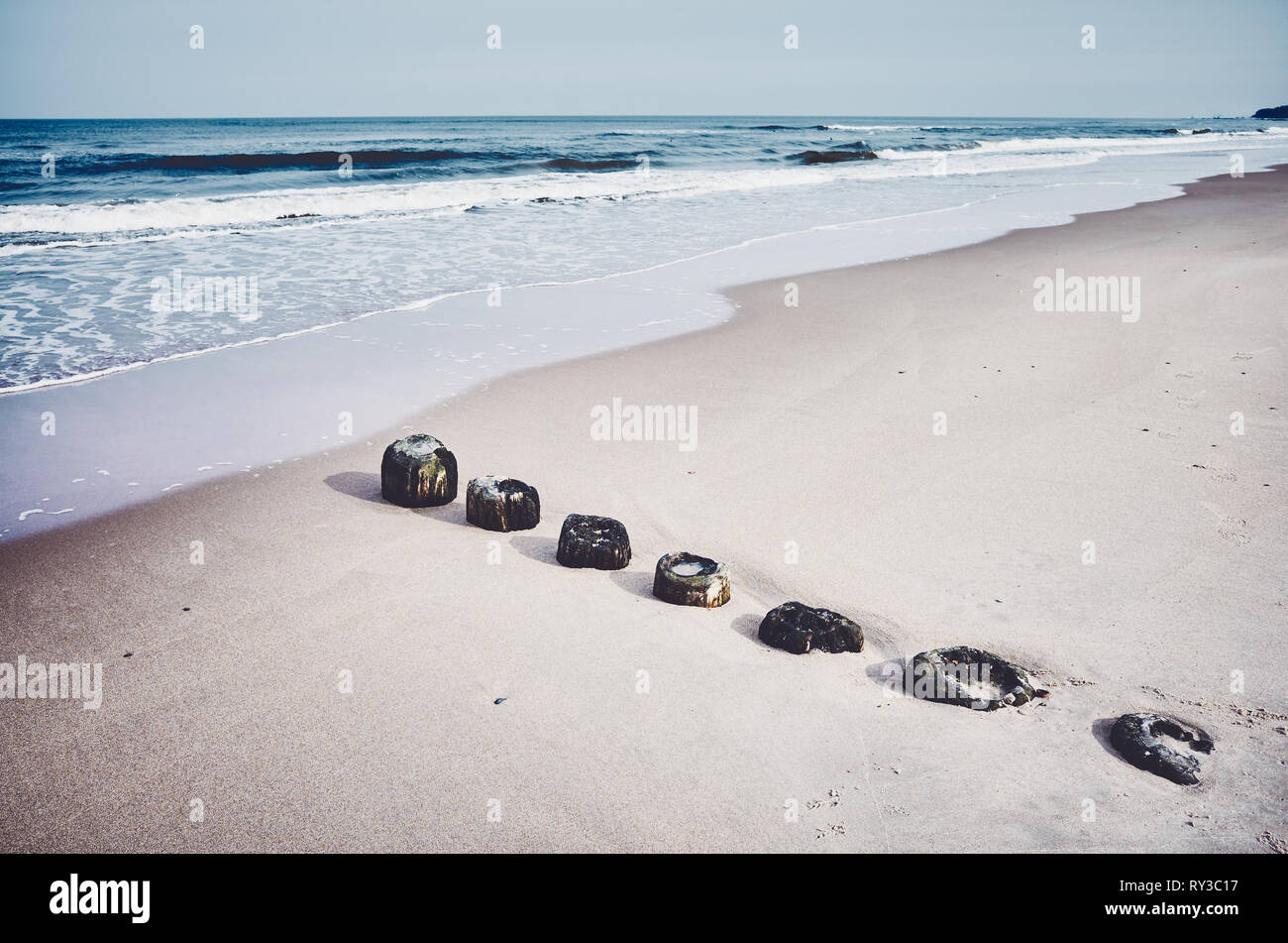 Alte hölzerne Meer Wellenbrecher bleibt auf einem Strand, selektiver Fokus, Farbe Tonen angewendet. Stockfoto